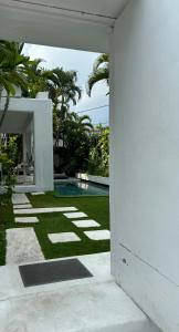 a white house with a yard with a swimming pool at Serenity Room at Villa Love in Seminyak