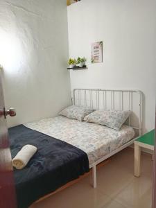 een klein bed in een kamer met een tafel bij Asyun Homestay 1 Double Storey House Sg Buloh Town in Sungai Buluh