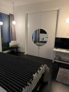 a bedroom with a bed with a mirror and a tv at Serenity Room at Villa Love in Seminyak