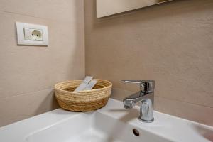 a bathroom sink with a basket on top of it at Apartamente Arad Premium in Arad +18 photos