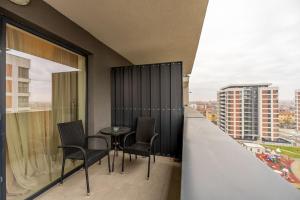 a balcony with chairs and a table on a building at Apartamente Arad Premium in Arad