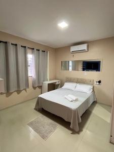 une chambre avec un lit blanc et une fenêtre dans l'établissement Acomodação para COP30, à Belém