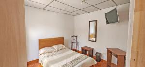 a bedroom with a bed and a flat screen tv at Casa del Pino in Popayan