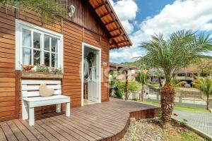 a wooden deck with a bench on a house at Cabana Coração: Romantismo, Banheira e Natureza in Gaspar Alto