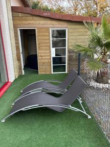 a chair on a lawn in front of a shed at maison chaleureuse ,avec piscine, spa, Futuroscope in Jaunay-Marigny
