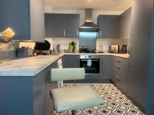 una cocina con armarios azules y una silla. en Van Loon Residence, en Oldbury 17 fotos más