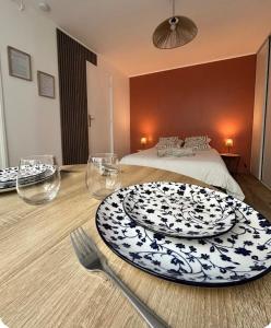 a table with a plate and fork and a bed at Charmant studio avec terrasse in Fécamp +7 photos