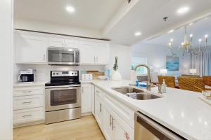 eine Küche mit weißen Schränken und Geräten aus Edelstahl in der Unterkunft High Pointe 2221 in Inlet Beach