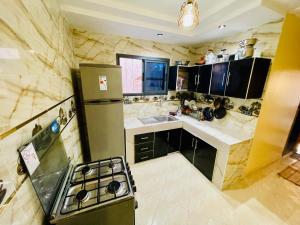 Il comprend une cuisine équipée d'un réfrigérateur et d'une cuisinière. dans l'établissement lovely surf house, à Taghazout