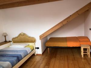 une chambre avec deux lits et un escalier dans l'établissement Ca' Stella, à Castello-Molina di Fiemme 10 autres photos