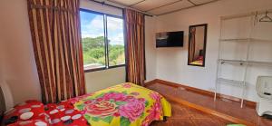 a bedroom with a bed and a large window at Casa del Pino in Popayan