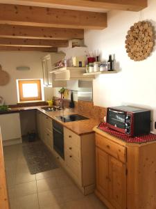 une cuisine avec un évier et un micro-ondes sur un comptoir dans l'établissement Ca' Stella, à Castello-Molina di Fiemme