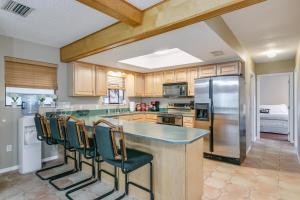 a kitchen with a counter with chairs and a refrigerator at Welcome to Your Serene Waterfront Getaway! in Cocoa