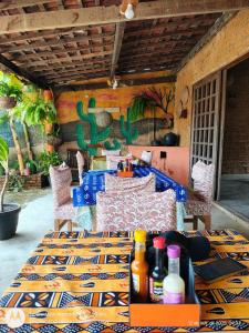 een tafel en stoelen in een kamer met een tafel en flessen bij Pousada Meu Xodó in São Miguel dos Milagres