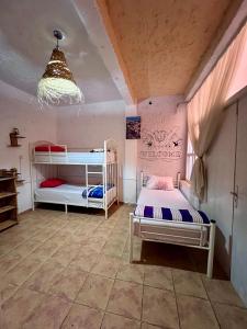 a bedroom with two bunk beds and a chandelier at TISLIT Surf Taghazout in Taghazout