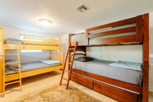 a room with three bunk beds and a ladder at Welcome to Your Serene Waterfront Getaway! in Cocoa