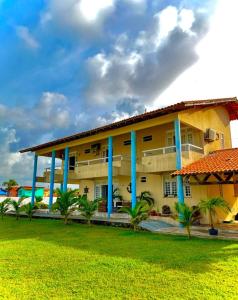 a building with palm trees in front of it at Casa do Lago Salinópolis in Salinópolis