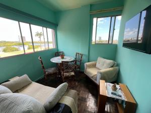 una camera con divano, tavolo e finestre di Lindo nascer do Sol II a Recife