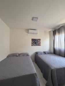 a bedroom with two beds and a window at Casa Delta 187 in Parnaíba +17 photos