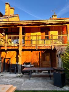 a wooden building with a deck and a picnic table at Gîte Les Plaisirs du Lac avec spa & sauna in Charchilla