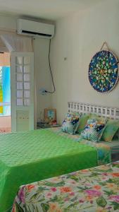 a bedroom with two beds with a green comforter at Casa do Lago Salinópolis in Salinópolis