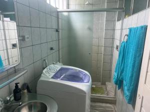 un bagno con lavatrice e lavandino di Lindo nascer do Sol II a Recife