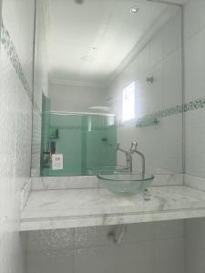 a bathroom with a glass sink and a mirror at Varanda das araras in Manaus
