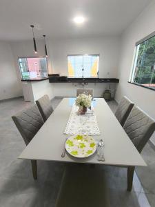 a dining room table with a plate and flowers on it at Varanda das araras in Manaus +9 photos