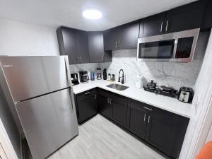 una cucina con mobili neri e un frigorifero in acciaio inossidabile di The Collection # 4 a Bradenton