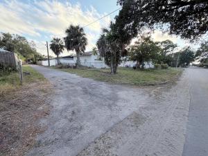 una strada sterrata vuota con alberi e una casa di The Collection # 4 a Bradenton