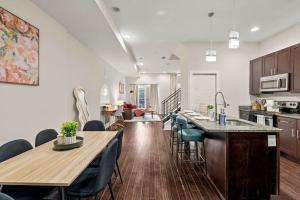 een keuken en woonkamer met een houten tafel en stoelen bij Modern 4BR City Escape Steps to MET & Subway Rooftop View in Philadelphia