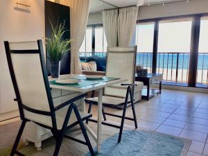 a dining room with a table and chairs in a living room at Shoreline Studio Condo for 4 in Galveston +36 photos