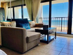 a living room with a couch and a table at Shoreline Studio Condo for 4 in Galveston