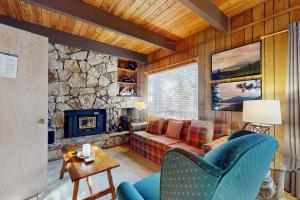 a living room with a couch and a stone fireplace at Talmont Trailhead Cabin in Tahoe City