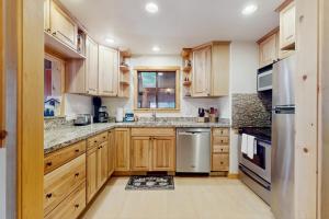 a kitchen with wooden cabinets and stainless steel appliances at Talmont Trailhead Cabin in Tahoe City
