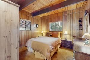 a bedroom with a bed in a room with wooden walls at Talmont Trailhead Cabin in Tahoe City
