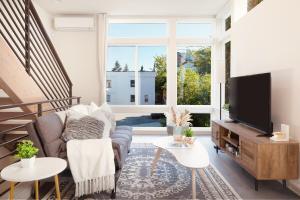 a living room with a couch and a tv at Modern Townhome with Lakeview in Seattle