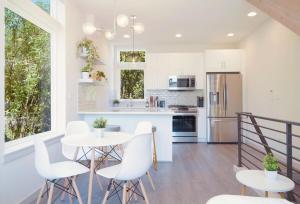 a kitchen with white appliances and white chairs and tables at Modern Townhome with Lakeview in Seattle