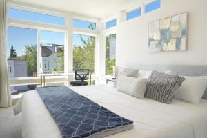 a bedroom with a large white bed with windows at Modern Townhome with Lakeview in Seattle