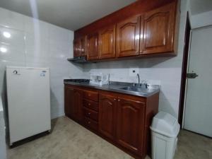 een keuken met houten kasten, een wastafel en een koelkast bij Apartment in Bogotá in Bogota +16 foto's