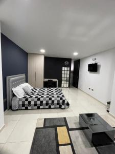 a bedroom with a black and white bed and a table at Evo Deluxe Room l Santa Rosa de Cabal in Santa Rosa de Cabal