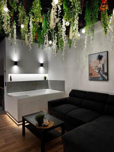 a living room with a couch and a table at Botanica Noir Jacuzzi Valaoritou in Thessaloniki