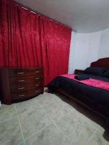 een slaapkamer met rode gordijnen en een bed en een dressoir bij Apartment in Bogotá in Bogota