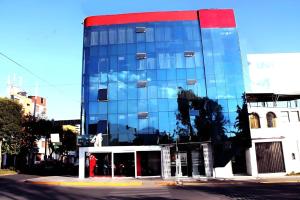 a blue glass building with a red top at Hotel Suite Los Inkas en Arequipa in La Pampilla