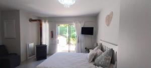 een slaapkamer met een wit bed en een glazen schuifdeur bij Muizenberg lakeside in Lakeside +29 foto's