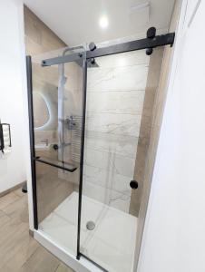 a glass shower door in a bathroom with a sink at Le 1930, la pause Béthunoise in Béthune +26 photos