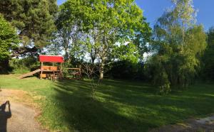 a park with a red structure in the grass at Gîte à la ferme I An Ti Ar Sav Heol in Sarzeau