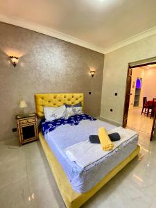 a bedroom with a large bed with a yellow headboard at Villa des Roses Privée in Marrakech