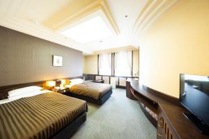 a hotel room with two beds and a television at Hotel Clio Court Hakata in Fukuoka +81 photos