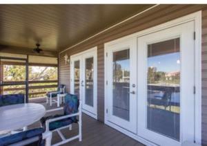 a porch with a table and chairs and a table and glass doors at Peace on the River, Breathtaking Views in Cocoa